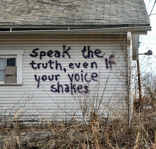 Tell the truth, even if your voice shakes! An abandoned building with "Speak the truth, even if your voice shakes" spray painted on the side.