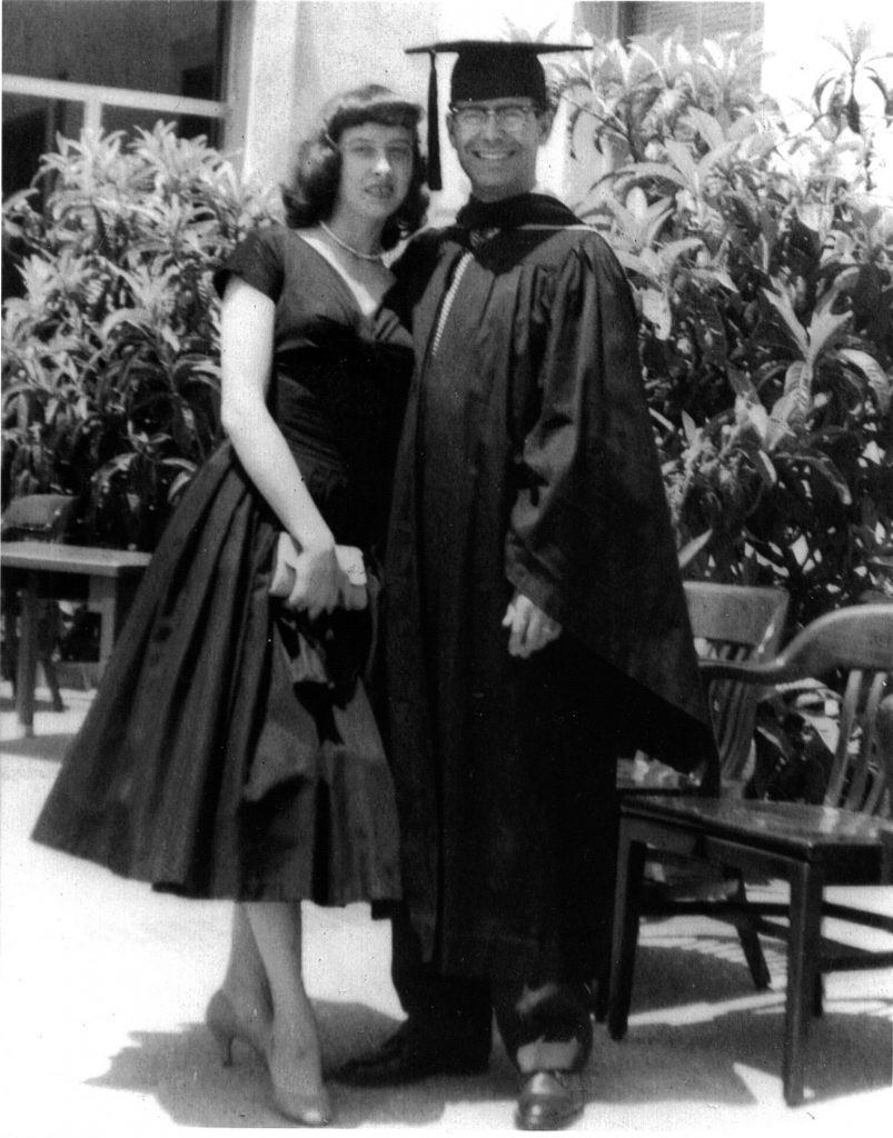 Missing Mom Cruz Reynoso in Law School graduation robes standing with his wife, Jeannene.