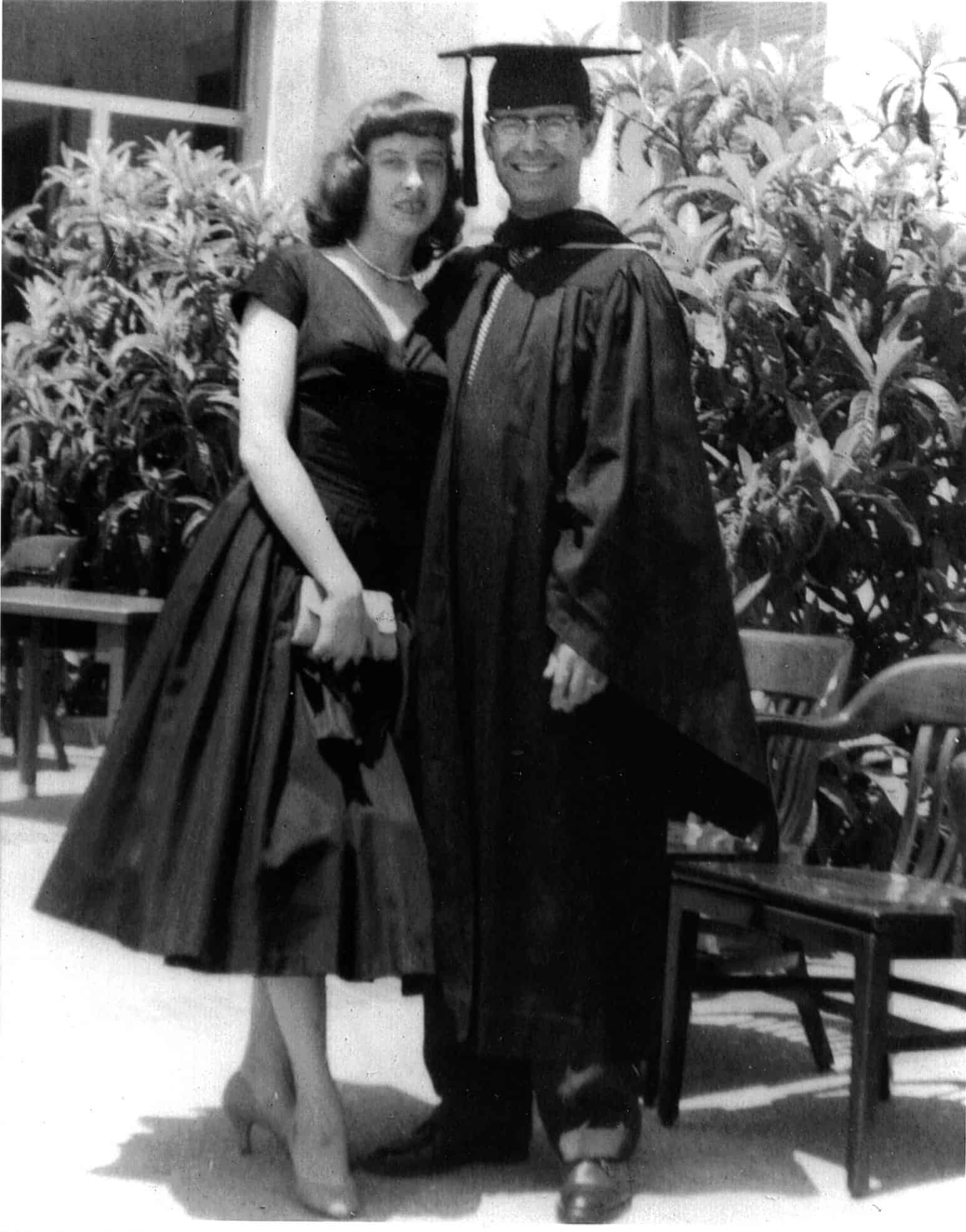 Cruz Reynoso in Law School graduation robes standing with his wife, Jeannene.