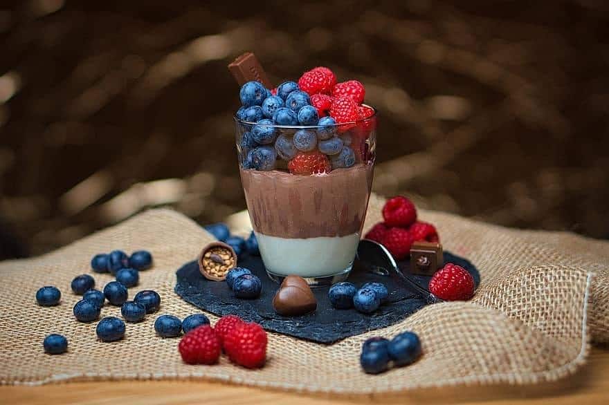 Why I’m Not Tempted to Apostate A glass dessert cup sits on a square of burlap and is filled with vanilla and chocolate pudding and topped with blueberries and raspberries.