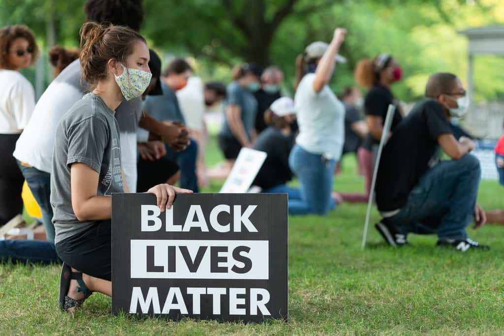praying with BLM sign