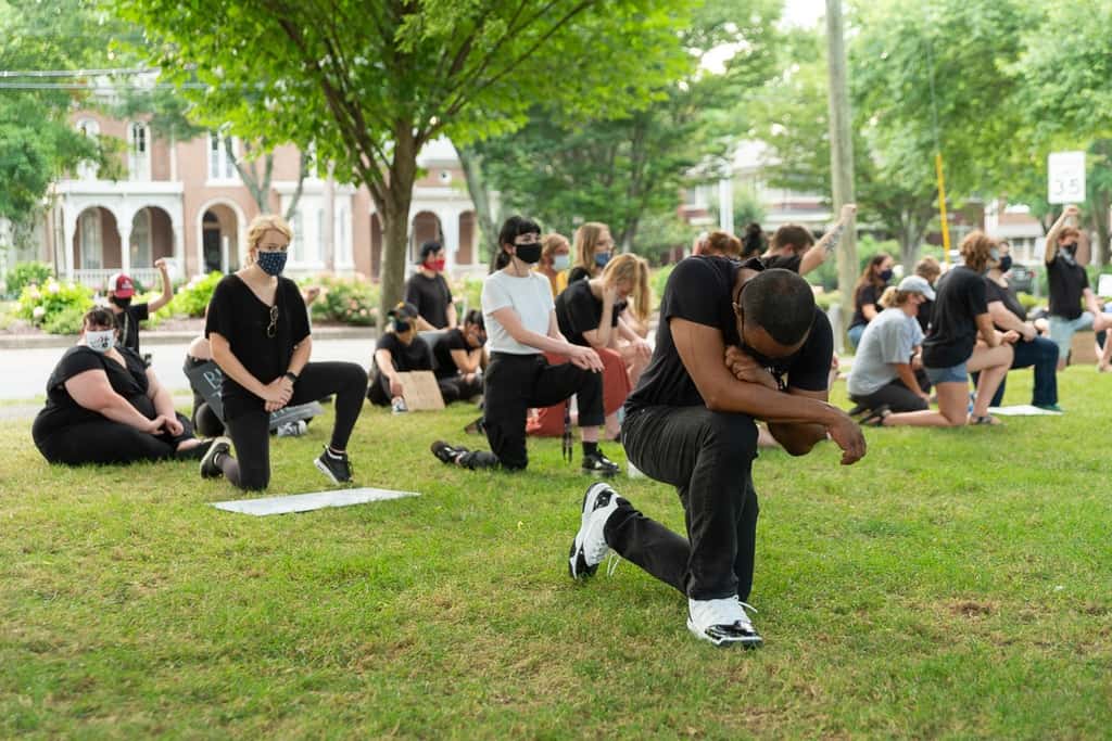 Demonstrators kneeling in prayer