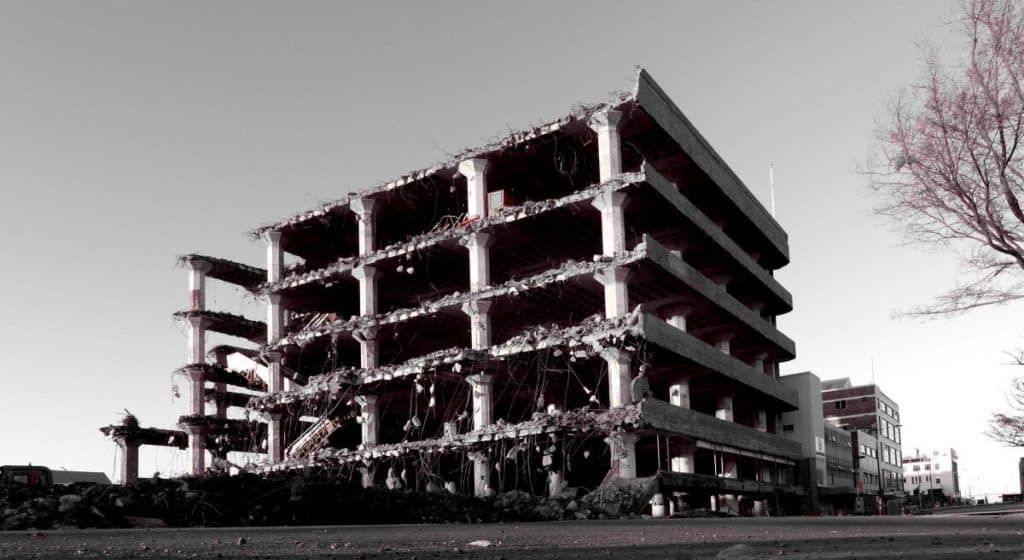 A partially deconstructed parking structure with the the front missing, is shown in black and white.