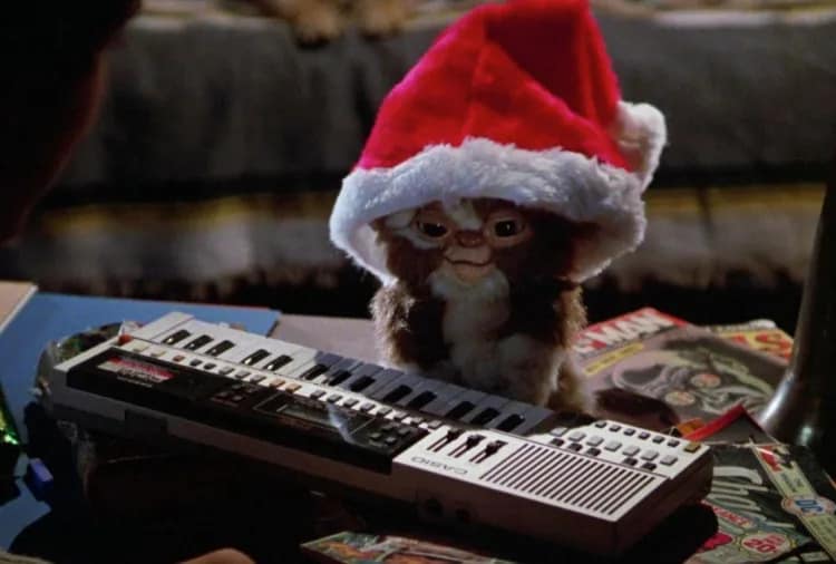 Confronting our little monsters: Gremlins and the legacy of spooky Christmas lessons A Gremlin wears a Santa hat and sits at a piano keyboard.