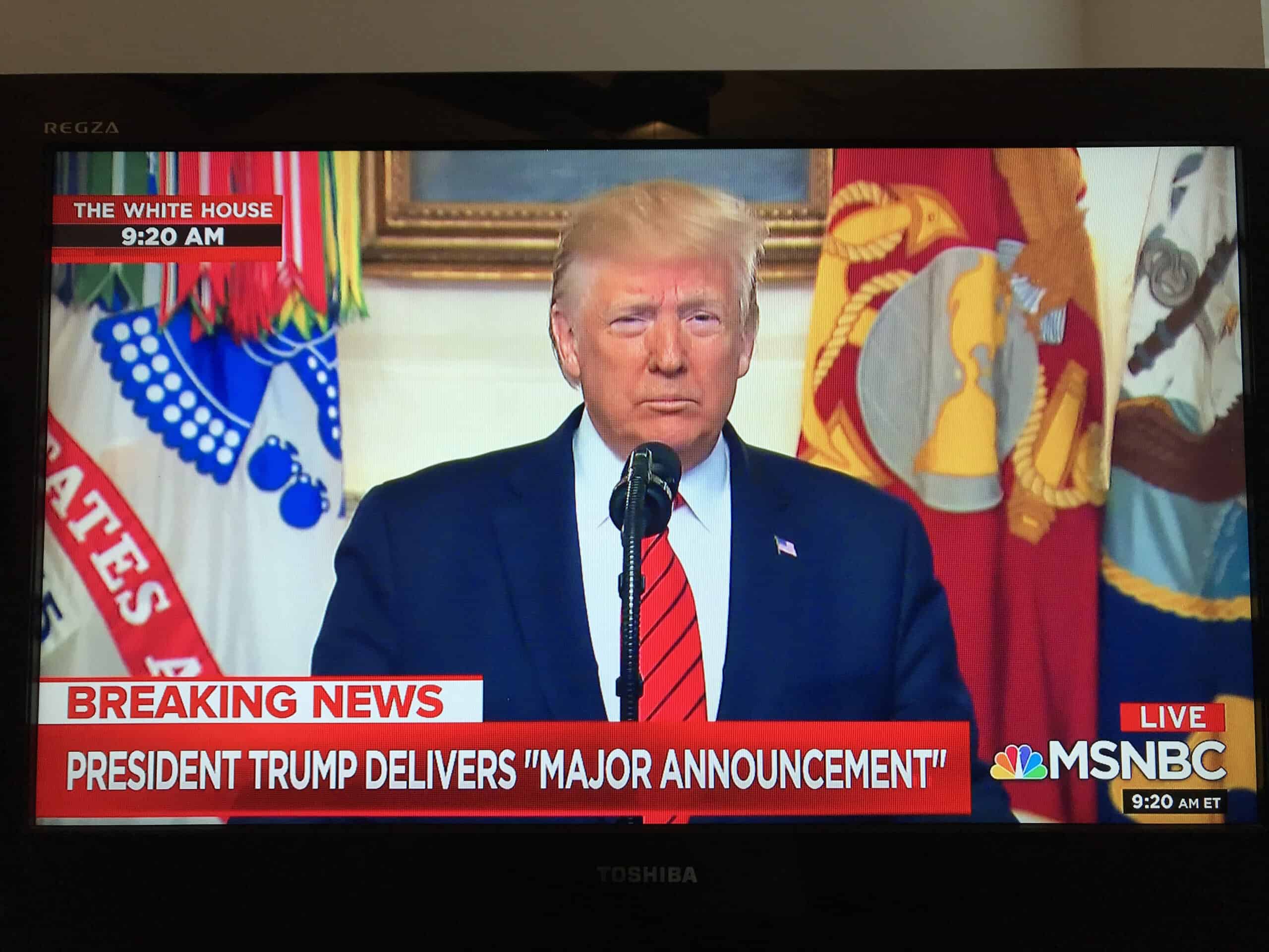 A screen shot from MSNBC shows former President Trump at a microphone.