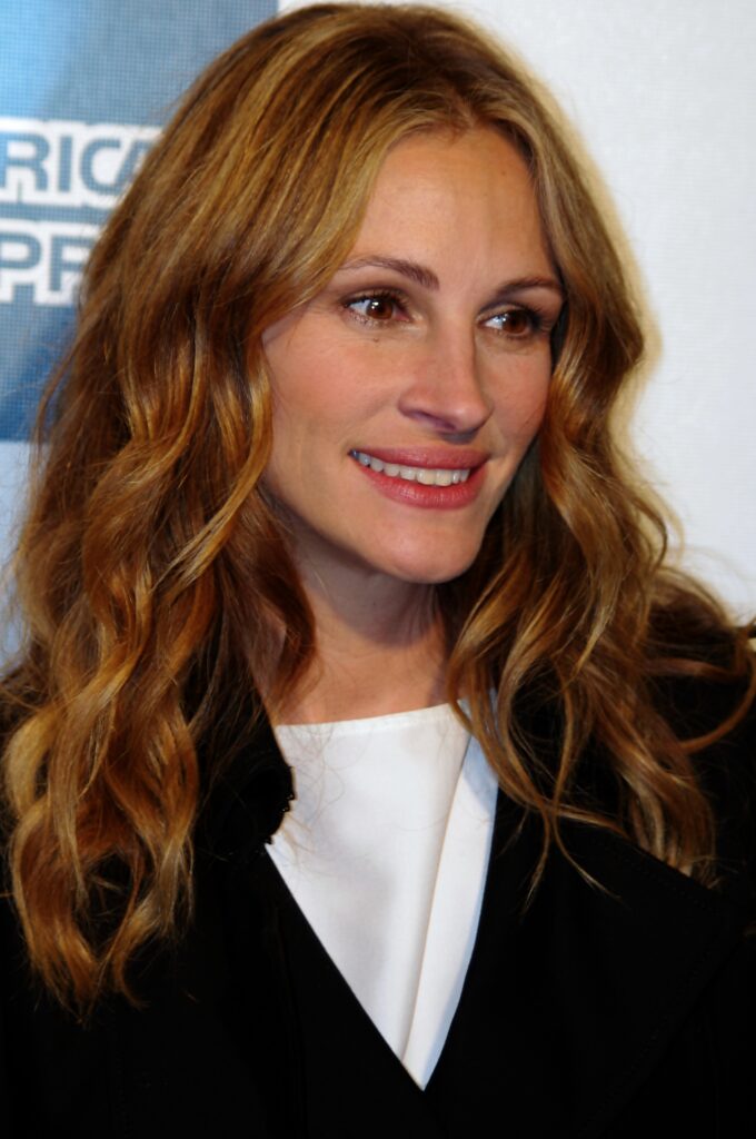 MLK paid hospital bill for the birth of Julia Roberts a candid photo of Julia Roberts smiling and wearing a black blazer and white shirt with her hair down