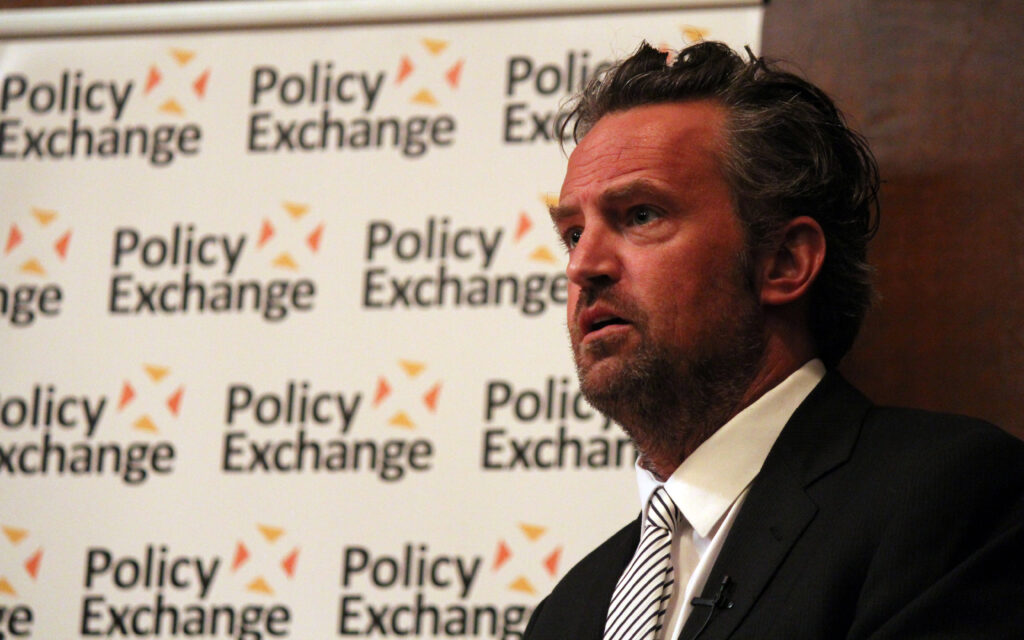 “I believe in a higher power; I have a close relationship with Him”: Matthew Perry to Bill Maher Matthew Perry, in a suit and tie, stands in profile view in front of a branded background