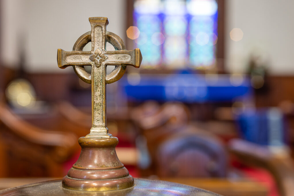 Pastors say Christians are loyal to politics over faith A close-up photo of a metal cross decoration that serves as the handle for an antique baptismal font at St. Luke's Episcopal Church in Cleveland, TN