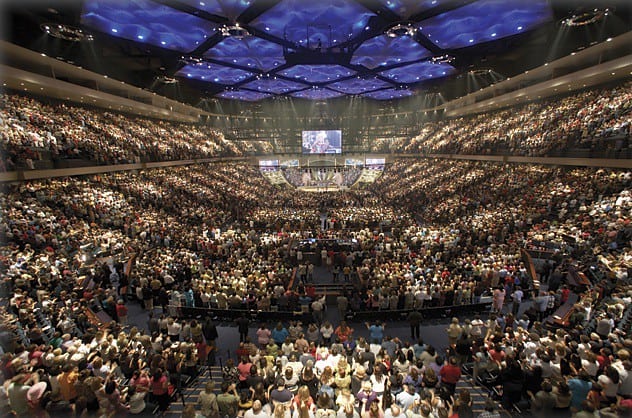 A very wide field of view shows a huge venue filled with people.