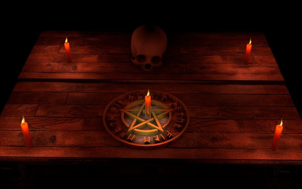 A pentagram is shown with a red candle in it's center, surrounded by other red candles and the whole image has a red cast.