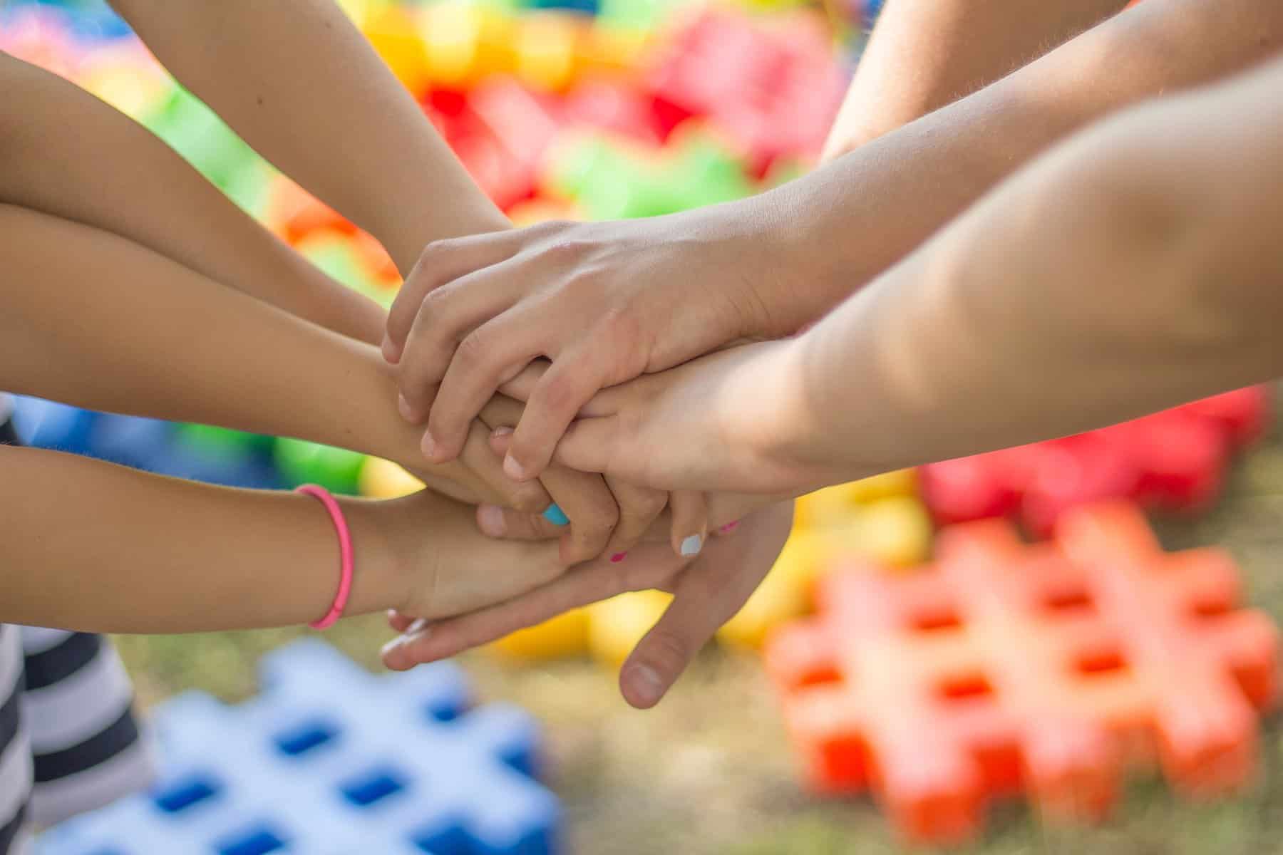 Children clasp hands over waffle blocks.