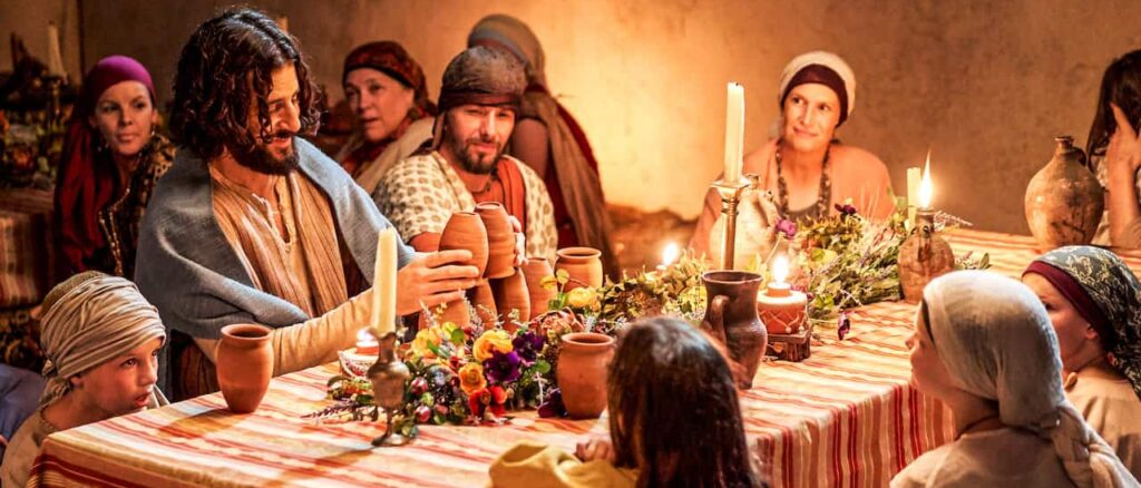 The Chosen- an image of the cast of the show with Jesus at a wedding
