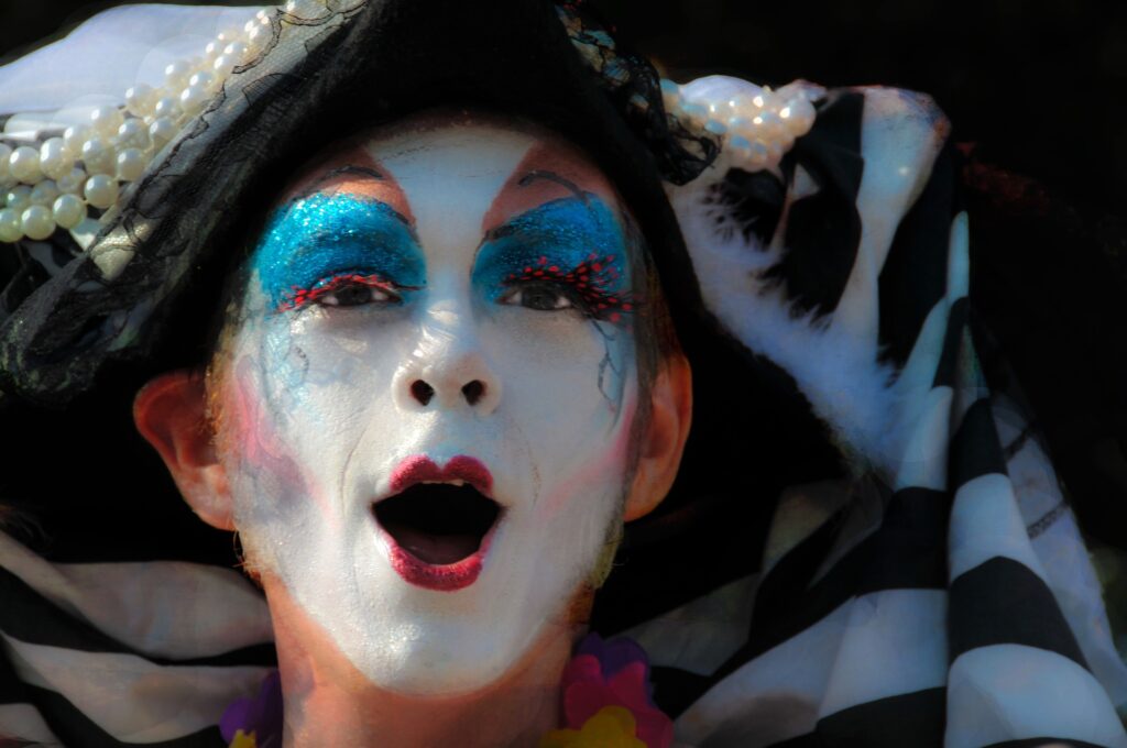 Dodgers disinvite, reinvite queer and trans group for LGBTQ+ Pride Night A performer with a heavily colored face like a mime is shown close up.