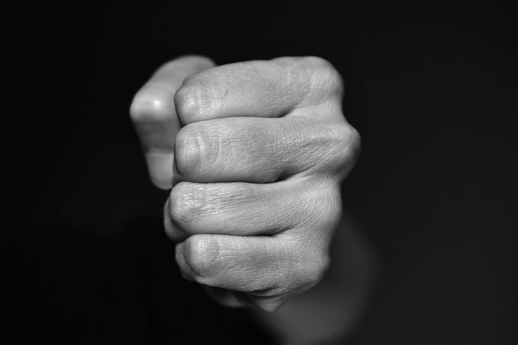 A tightly clenched fist is shown close up in the this black and white image.