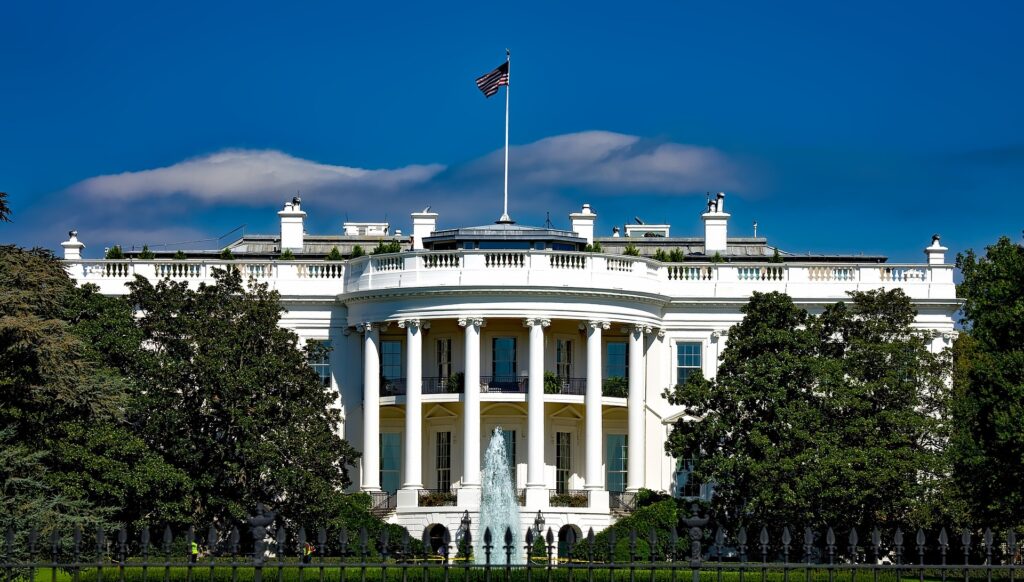 A photo of the White House is shown on a clear day.
