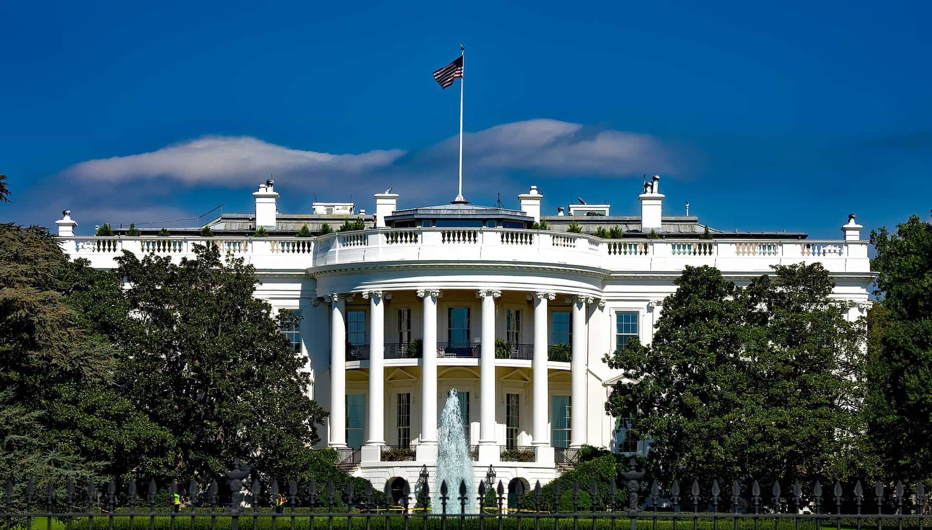 A photo of the White House is shown on a clear day.
