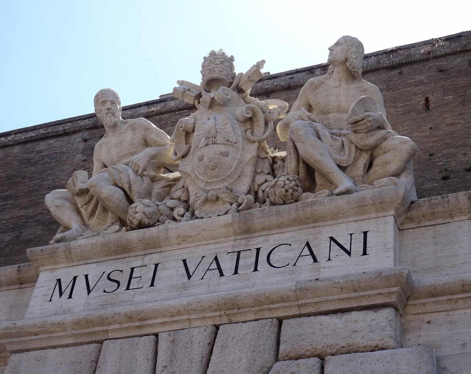 The carved entrance with three figures to the Vatican Museums is shown.