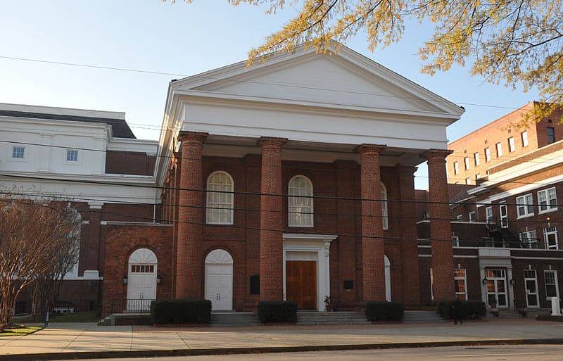 A two story brick church is shown from the street.
