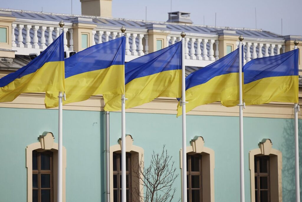 Odesa cathedral heavily damaged in Russian attack Five flags of Ukraine as seen flying on flagpoles in front of a building.