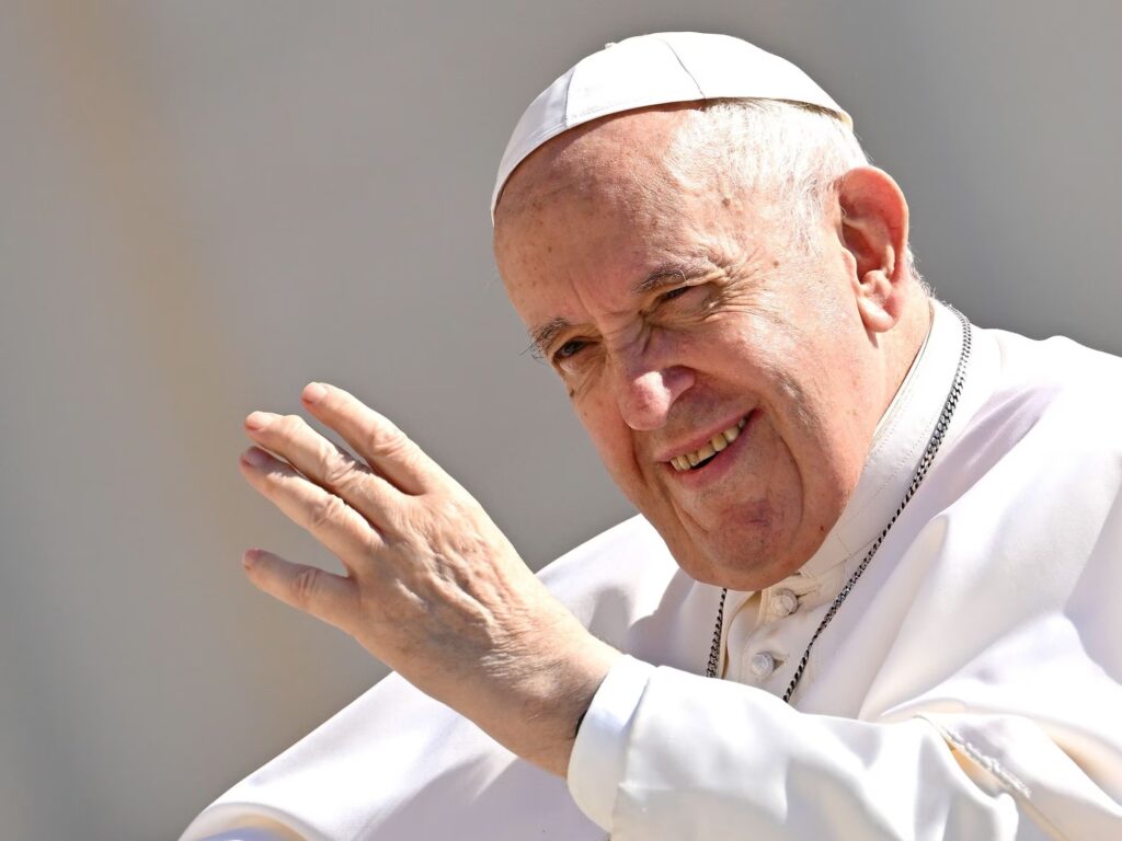 The pope calls for urgent global action to combat climate change The pope is shown waving his hand and dressed in white.