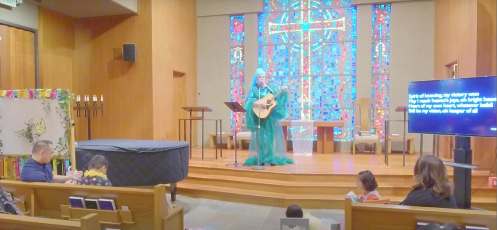 The colorful altar decorated in blues and with a stained glass backdrop is shown.