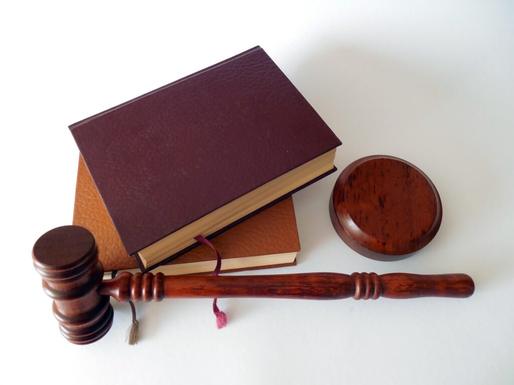 Christian social worker seeks legal action after job withdrawal, requirement to support LGBTQ rights Two books are stacked with a judge's gavel laying in front of them.