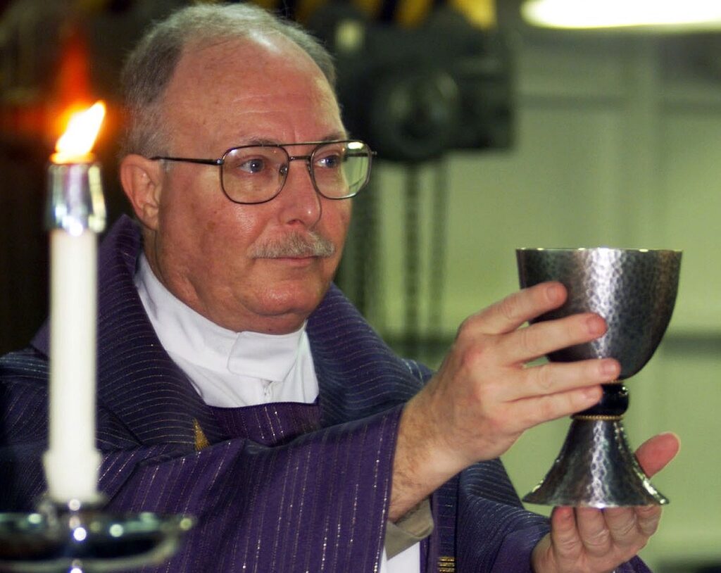 Catholics secure win for full Mass in Alaska prisons as wine rules are amended A priest holds a communion chalice aloft.