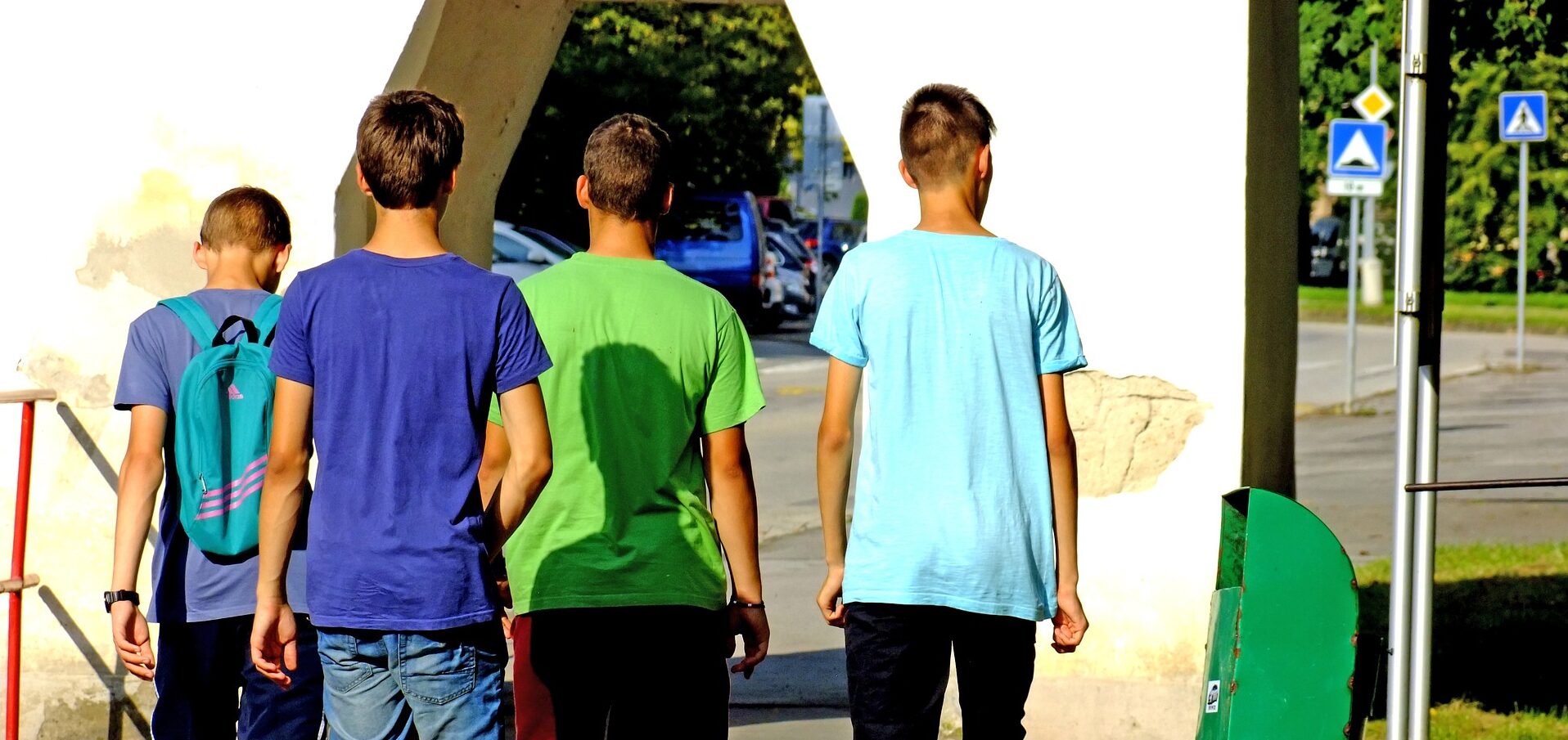 A group of young people are shown walking away from the camera.