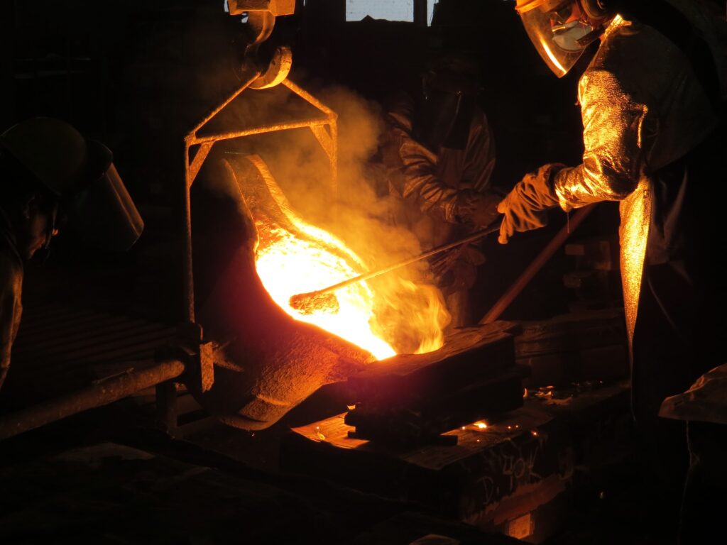 Challenging the influence of Trump and Tuberville with the love of Christ A metal worker wearing protective heavy clothing holds an iron in molten metal.