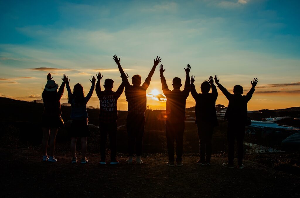 World Youth Day: 96% of attendees believe gatherings foster evangelization A group of people stand in silhouette with arms raised with the sunset behind them.
