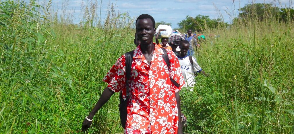 Cardinal Parolin delivers Pope Francis' message of peace to South Sudan A line of Sudanese people are shown walking toward the camera.