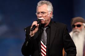 Joe Bonsall of the Oak Ridge Boys holding a microphone.