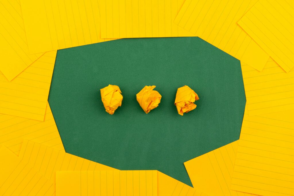 Campus Culture Wars: A threat to free speech and discourse Yellow and green paper are used to create a green speech bubble with yellow paper ellipses.
