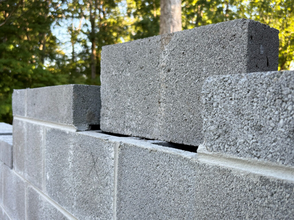 U.S. Tax Code: How might it change under Project 2025? A cinder block capstone on it's side, waiting to be set between to others.