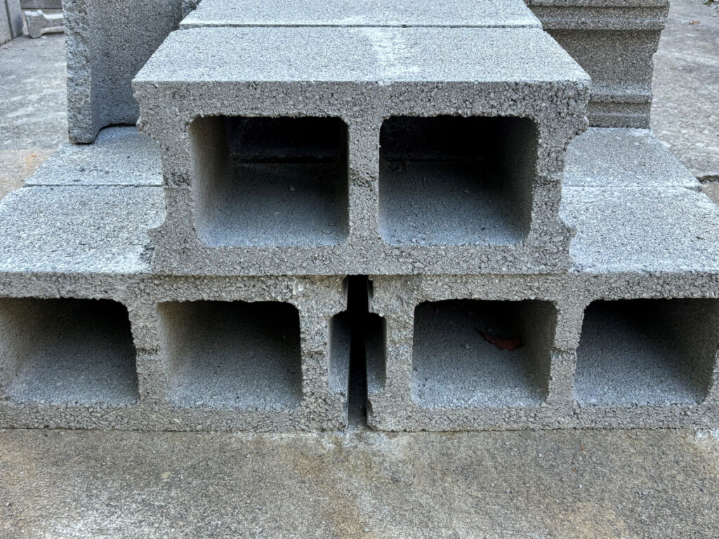 Project 2025: Who Are Its Architects? Stacked grey cinder blocks.