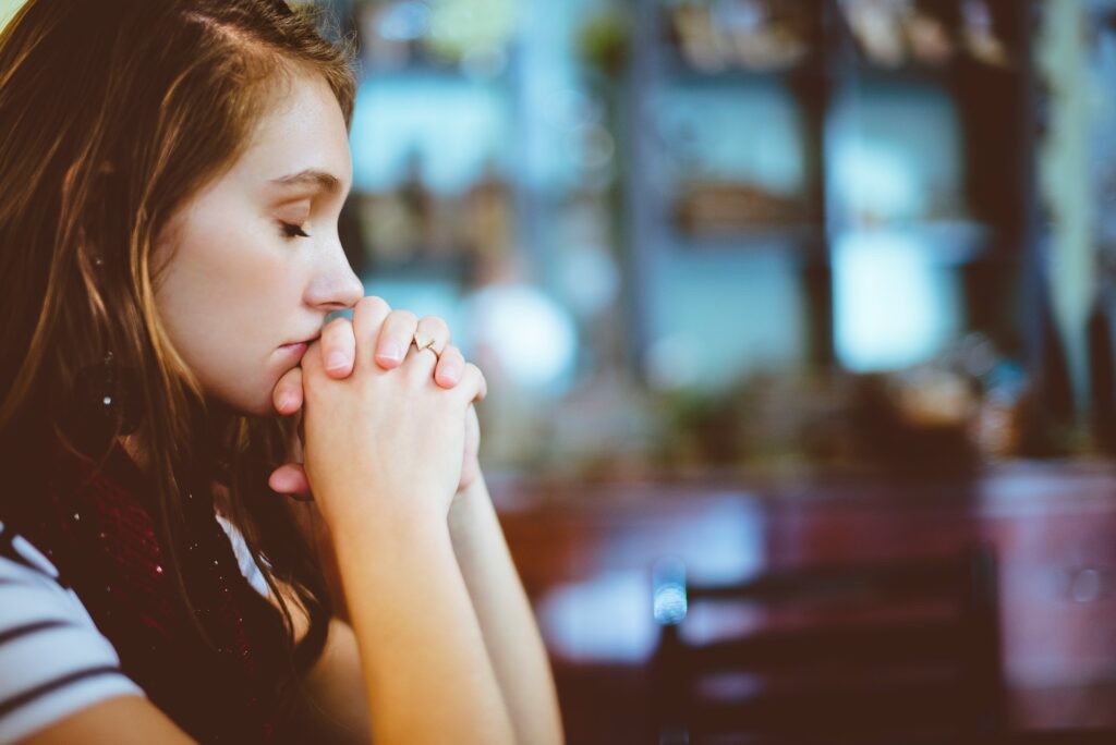 How family faith traditions shaped my life beyond politics A woman has her hands folded in prayer.