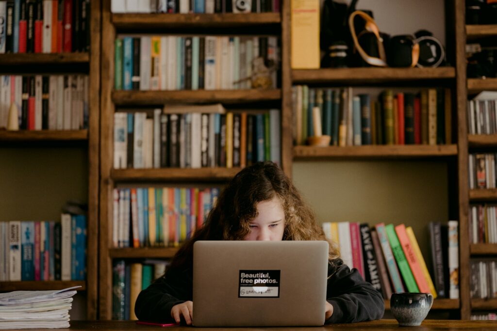Religious schools gain ground with Ohioโs new public funding policies A girl sits behind and is half obscured by a desk and laptop.