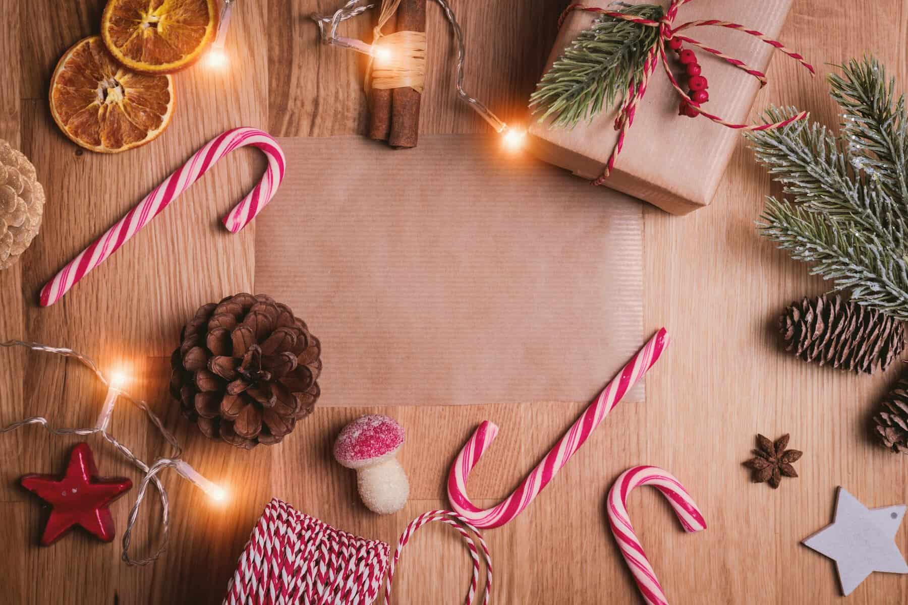 Christmas lights, candy canes, and wrapping on a table.
