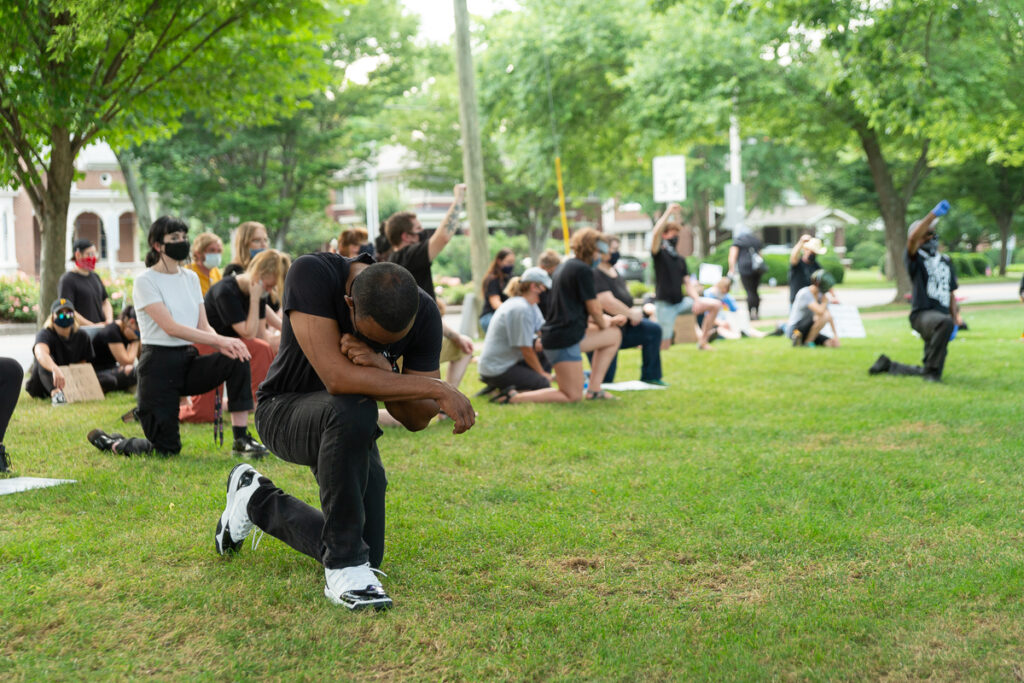 New Credo urges Black empowerment amid white Christian Nationalism threats A Black man kneels on one knee in protest with head bowed.