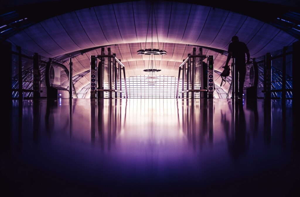 Calvin University: A hub for global education and diversity Moody photo of a man in an airport about to go down an escalator.