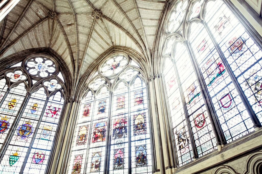 Men now outpace women in church attendance: 2025 Barna Report stained glass windows seen close up from below.