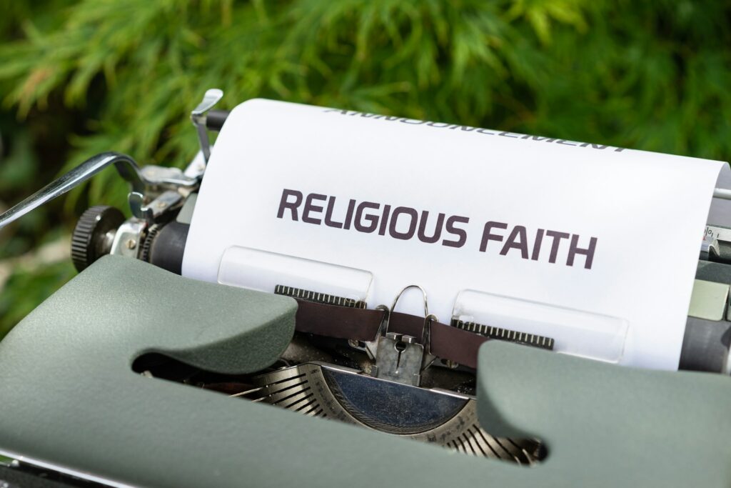 A typewriter with a paper saying Religious Faith.