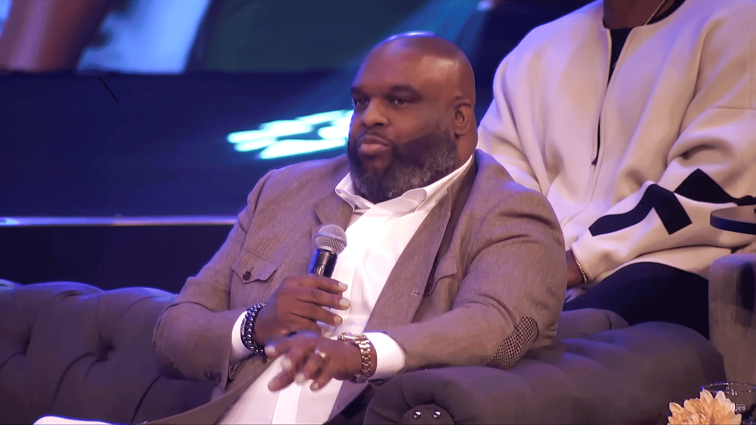 Pastor John Gray sits with microphone