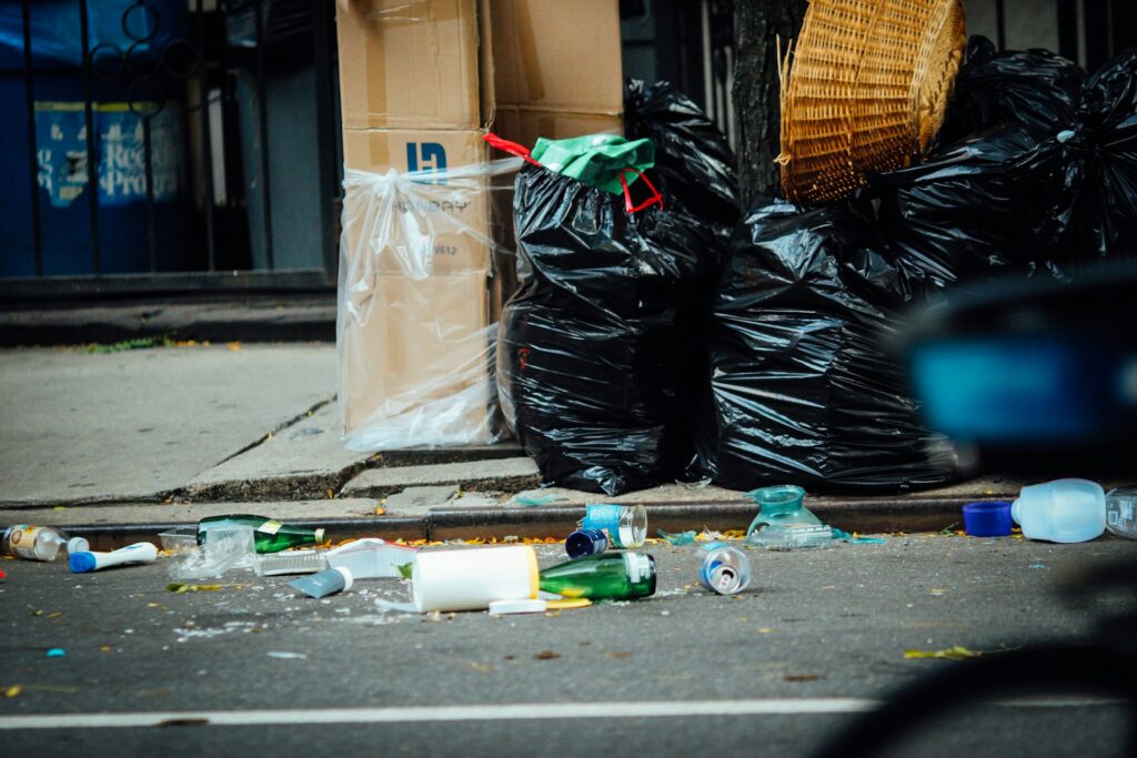 Pastor accused of coercion and abuse in New Jersey church labor scheme Trash bags and liter on a city street.