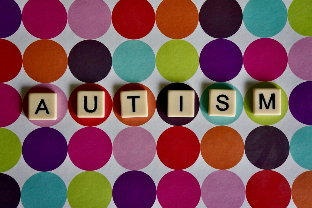 Kennedy’s $50M autism initiative sparks scientific and privacy concerns "Autism" spelled on Scrabble tiles on a polka-dotted background.