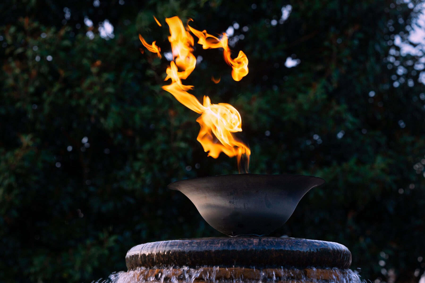 A flame on top of a water fountain.