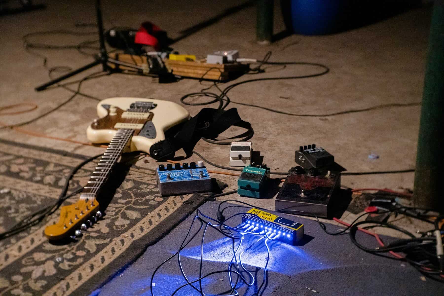 Guitar and music gear strewn around.