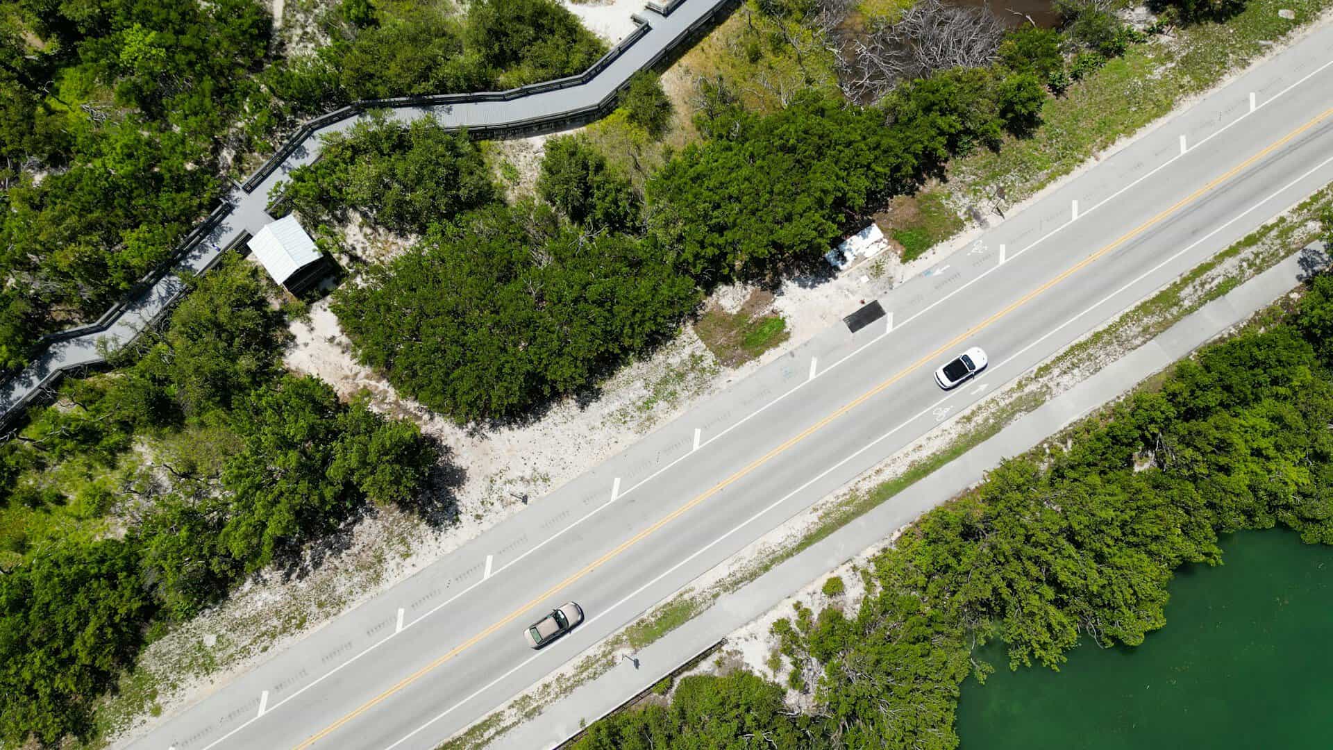 Cars seen from above driving down an ocean front road.