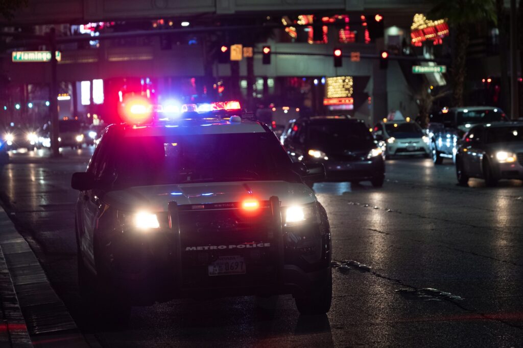 Police car at night with colored lights on.