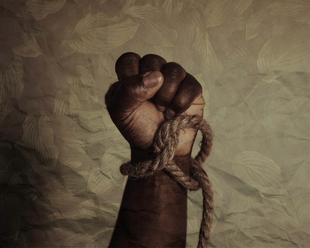 Juneteenth: A sacred pause for liberation and faith A Black man's raised fist with a loose rope around the wrist.